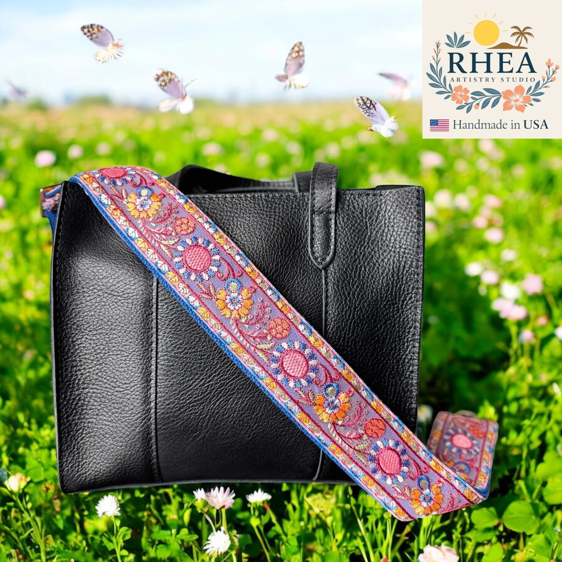 Rhea Artistry Studio 2-inch wide crossbody strap with vibrant zinnia embroidery in pink, orange, and blue on a lavender background, featuring brushed brass hardware.