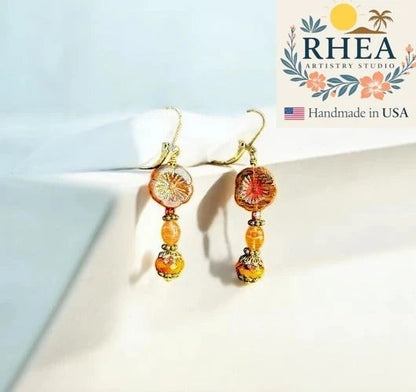 Rhea Artistry Studio mustard hibiscus drop earrings with brass accents, approx. 1.5-2 inches long, handcrafted in USA.