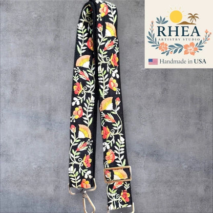 Floral patterned purse strap with RHEA Artistry Studio logo on a gray background