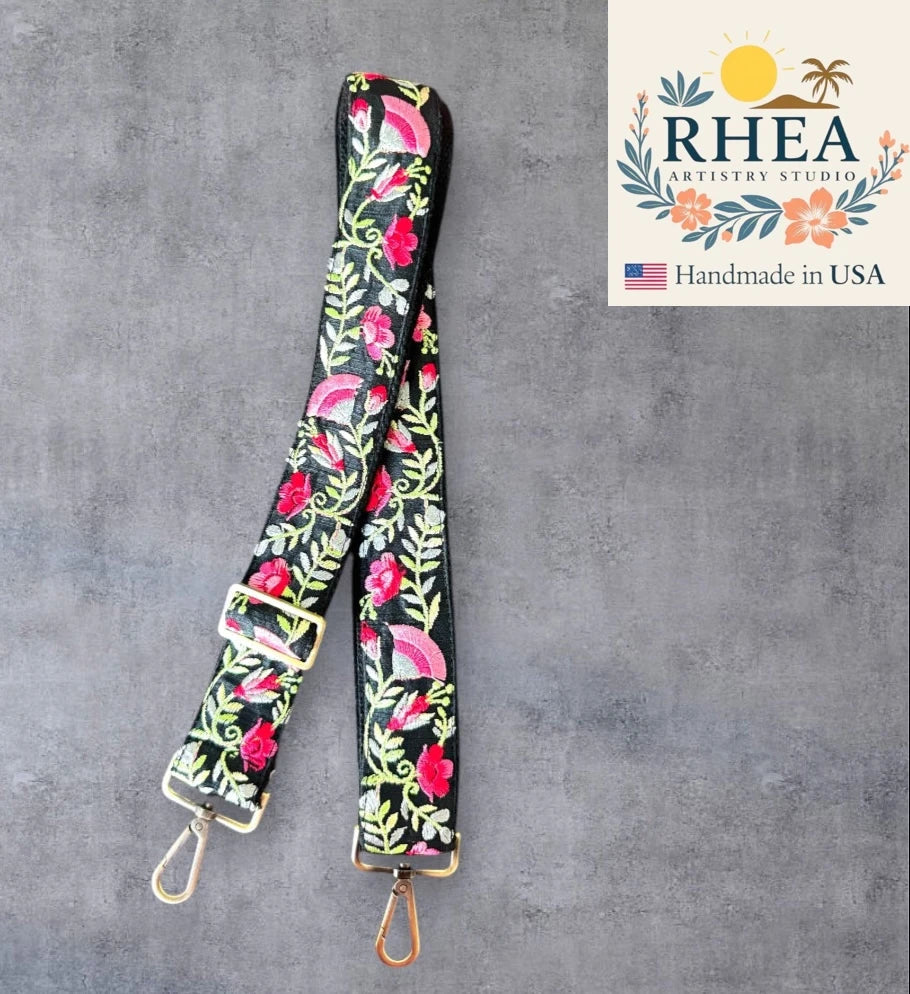 Floral patterned purse strap with gold hardware on a gray background, featuring RHEA Artistry Studio logo.