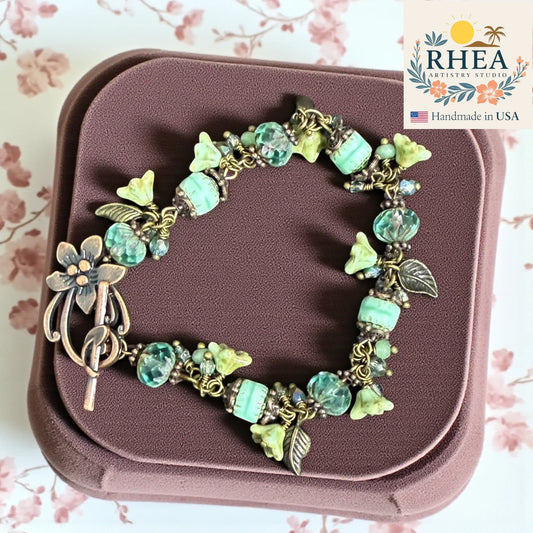 Handcrafted Sea Glass Bloom Bracelet featuring Czech glass beads, natural gemstones, and silver metal accents in ocean-inspired aqua tones.