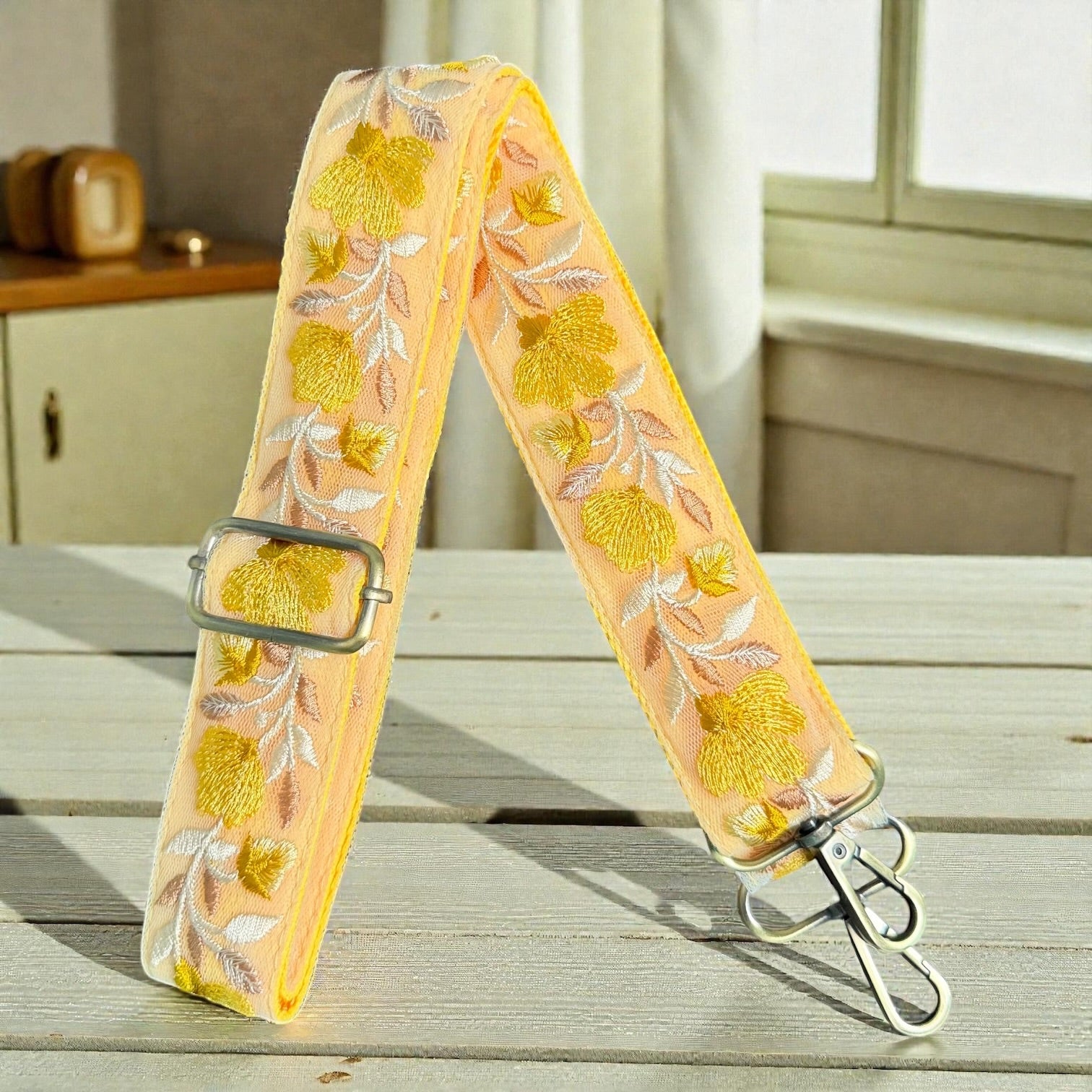 flat lay of Cotton webbing backing on a 1.5 inch embroidered lace strap, Decorative strap with floral pattern on a wooden surface